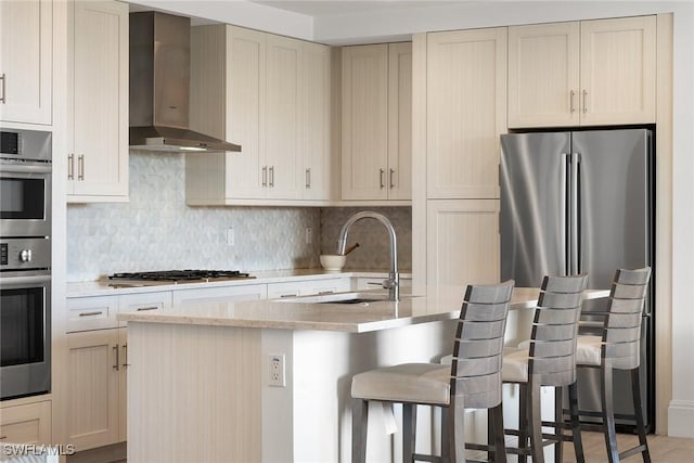 1135 3rd Ave S Unit 317, Naples, FL 34102 - kitchen with wall chimney exhaust hood, a sink, stainless steel appliances, tasteful backsplash, and a breakfast bar