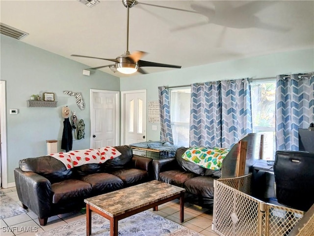 living room with a ceiling fan, visible vents, vaulted ceiling, and light tile patterned floors