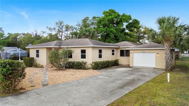 single story home featuring an attached garage, driveway, and a front lawn