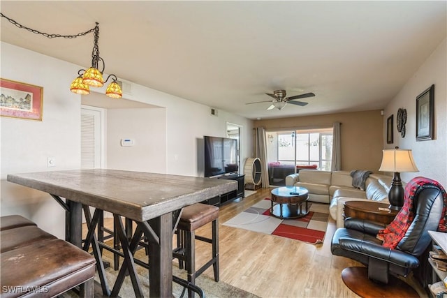 living area featuring visible vents, wood finished floors, and a ceiling fan