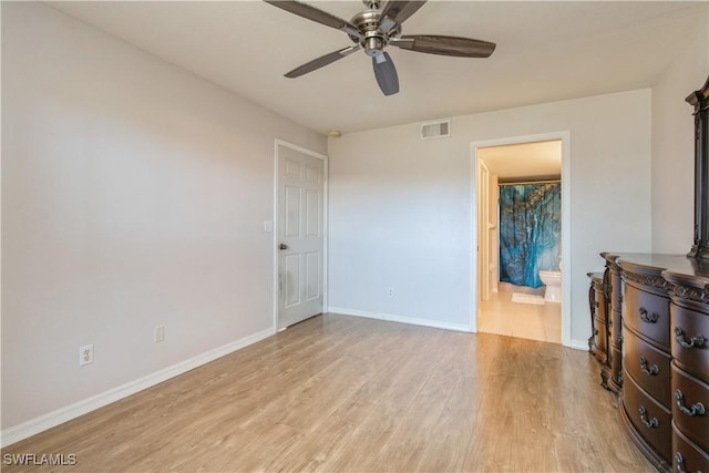 unfurnished bedroom with visible vents, ensuite bath, wood finished floors, baseboards, and ceiling fan