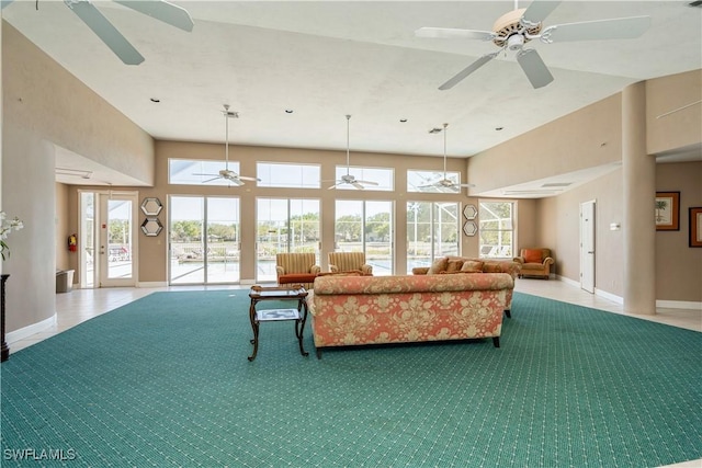 living room with tile patterned flooring, a healthy amount of sunlight, and a high ceiling