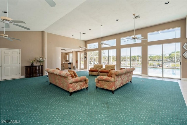 living room with carpet flooring, visible vents, and a towering ceiling