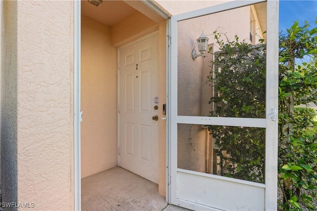 view of exterior entry featuring stucco siding