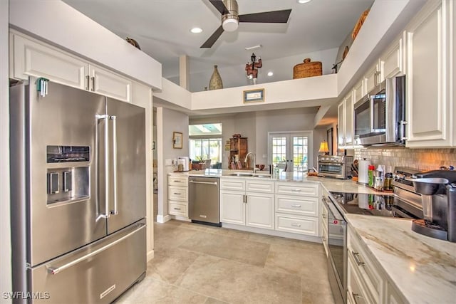 12488 Kelly Pine Ct, Fort Myers, FL 33908 - kitchen with a ceiling fan, a sink, backsplash, white cabinetry, and stainless steel appliances