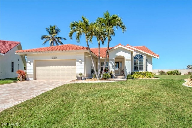 mediterranean / spanish house with a garage, a front lawn, driveway, and a tile roof