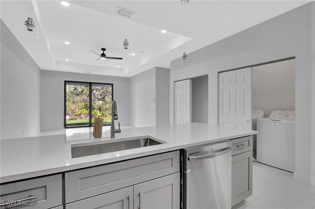 kitchen featuring a tray ceiling, visible vents, a sink, separate washer and dryer, and dishwasher