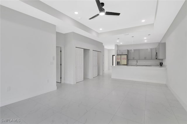 unfurnished living room with marble finish floor, recessed lighting, a ceiling fan, a sink, and baseboards