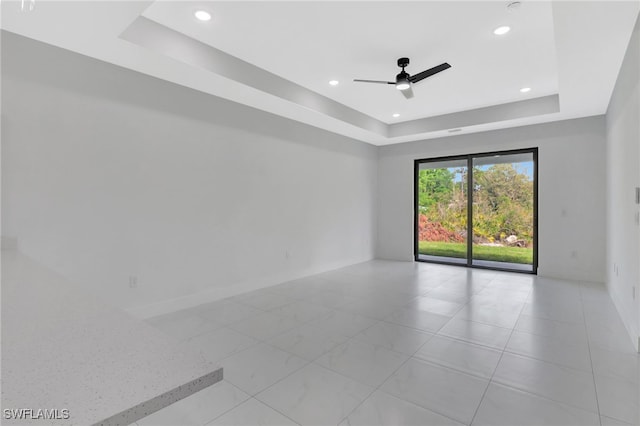 empty room with baseboards, a raised ceiling, a ceiling fan, and recessed lighting