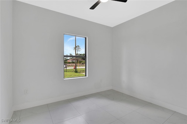 empty room featuring ceiling fan and baseboards