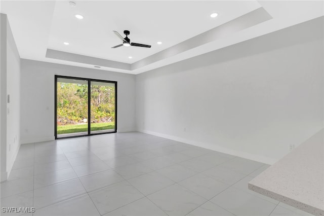 spare room featuring baseboards, a tray ceiling, a ceiling fan, and recessed lighting