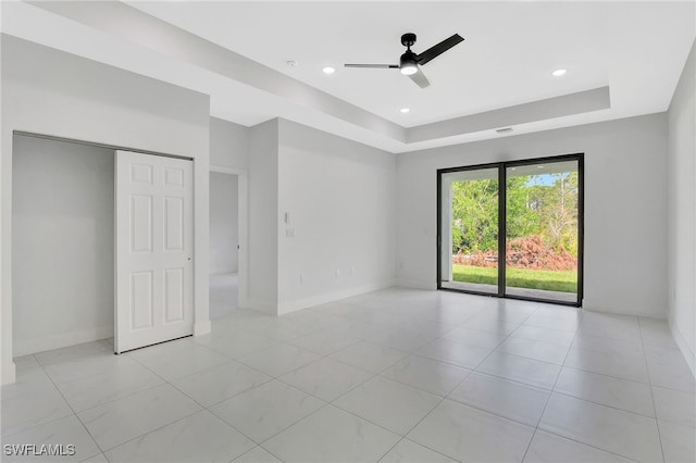 spare room featuring baseboards, a raised ceiling, a ceiling fan, and recessed lighting