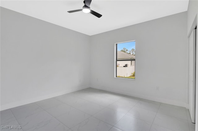 unfurnished room featuring ceiling fan and baseboards