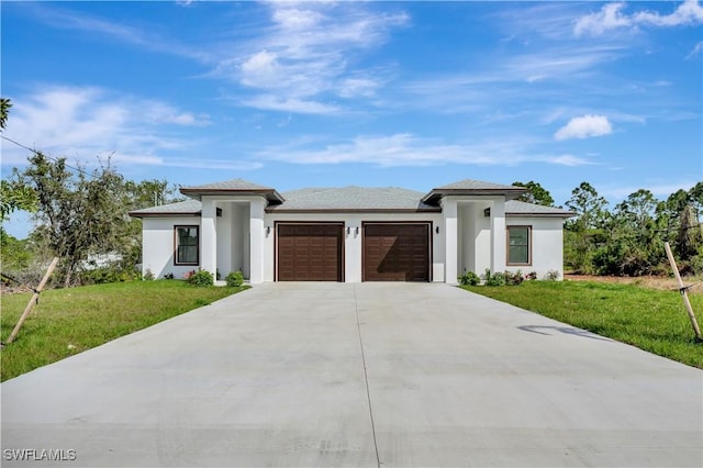 prairie-style home with a garage, stucco siding, driveway, and a front yard