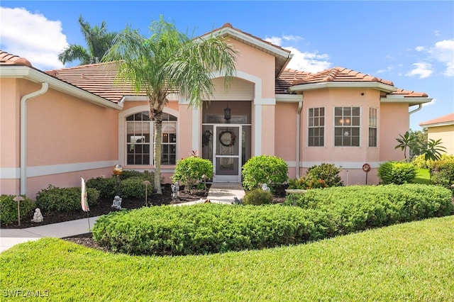 mediterranean / spanish house with a tile roof and stucco siding