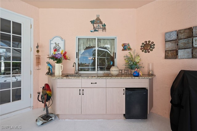 interior space featuring light stone counters, a sink, and light tile patterned floors