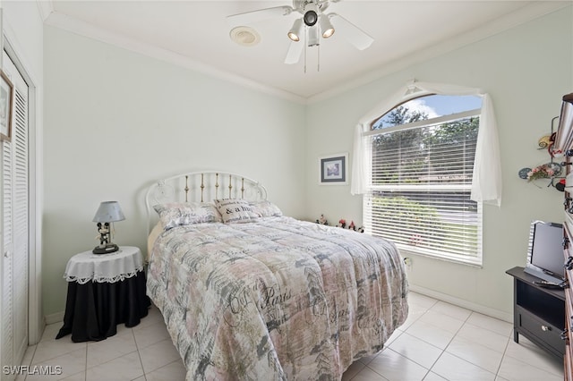 bedroom featuring ornamental molding, a closet, baseboards, and light tile patterned floors