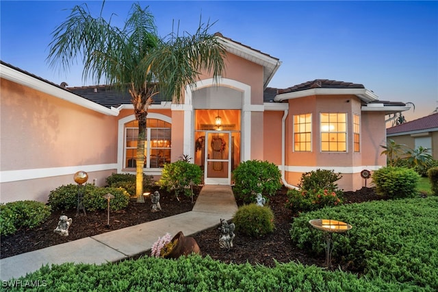 property entrance featuring a tiled roof and stucco siding