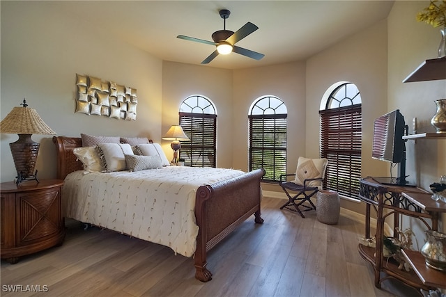 bedroom featuring ceiling fan, wood finished floors, and baseboards