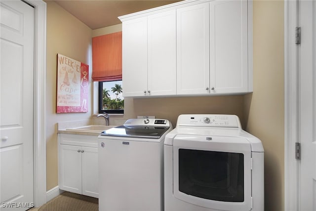 clothes washing area featuring cabinet space, a sink, and separate washer and dryer