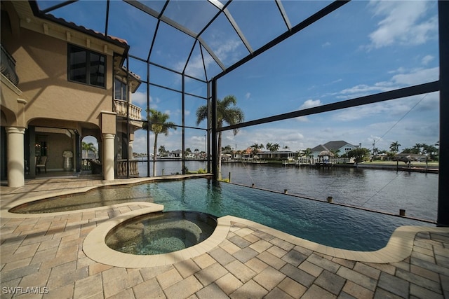 view of pool featuring a pool with connected hot tub, a lanai, a water view, and a patio