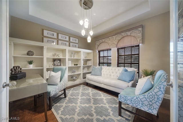 home office with wood finished floors and a raised ceiling