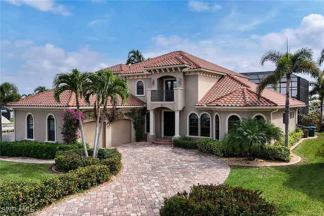 mediterranean / spanish-style home featuring a tiled roof, a balcony, a garage, and stucco siding