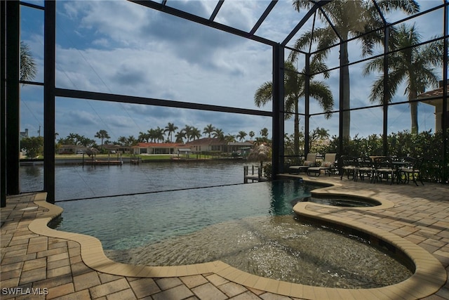 view of pool with a pool with connected hot tub, glass enclosure, and a patio