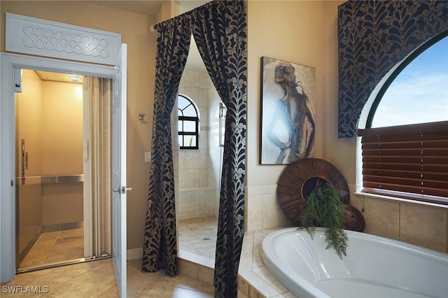 bathroom with tile patterned flooring, a tile shower, and a bath