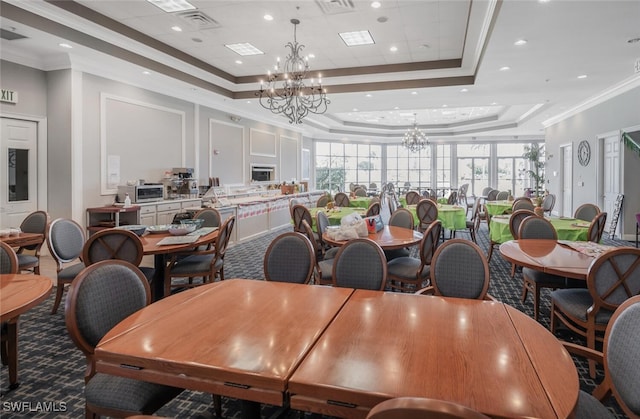 carpeted dining space with crown molding, a tray ceiling, an inviting chandelier, and a toaster