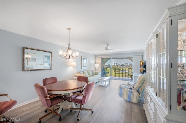 dining room with ceiling fan with notable chandelier, crown molding, wood finished floors, and baseboards