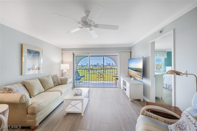 living room featuring ceiling fan, ornamental molding, a healthy amount of sunlight, and light wood-style floors