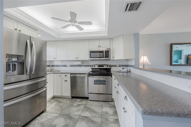 kitchen featuring crown molding, appliances with stainless steel finishes, a tray ceiling, and visible vents
