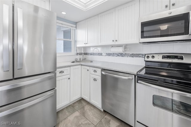 kitchen featuring light countertops, white cabinetry, appliances with stainless steel finishes, and a sink