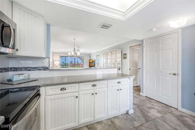 kitchen with visible vents, ornamental molding, a peninsula, stainless steel microwave, and a chandelier