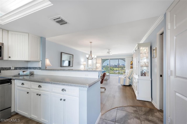 kitchen with ornamental molding, a peninsula, white cabinetry, and visible vents