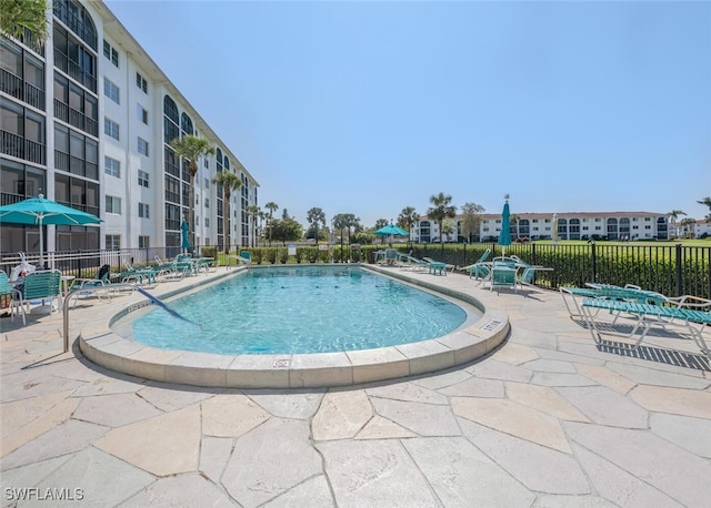 pool featuring fence and a patio
