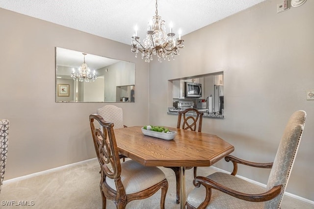 carpeted dining room featuring a chandelier, a textured ceiling, and baseboards