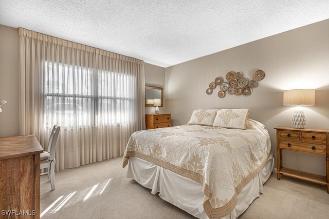 bedroom featuring light carpet and a textured ceiling