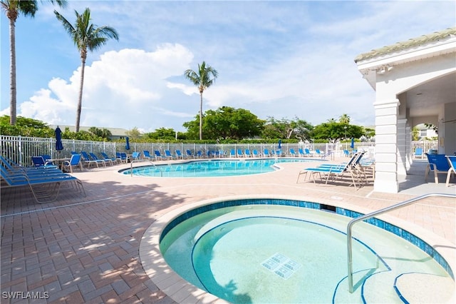 community pool featuring a community hot tub, a patio, and fence