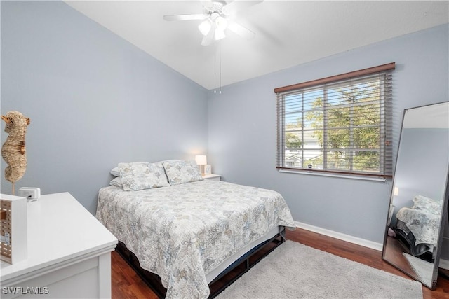 bedroom with a ceiling fan, dark wood-type flooring, baseboards, and vaulted ceiling