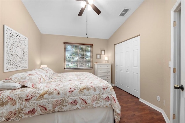 bedroom featuring visible vents, lofted ceiling, ceiling fan, dark wood-type flooring, and a closet