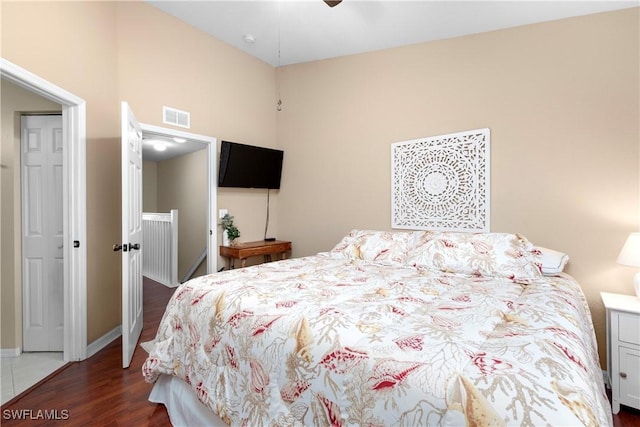 bedroom with dark wood-type flooring, baseboards, and visible vents