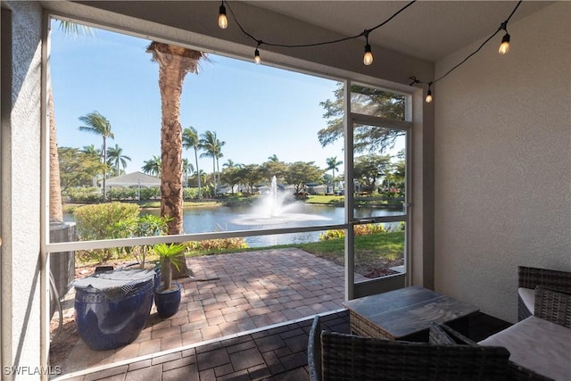 sunroom / solarium featuring a wealth of natural light and a water view