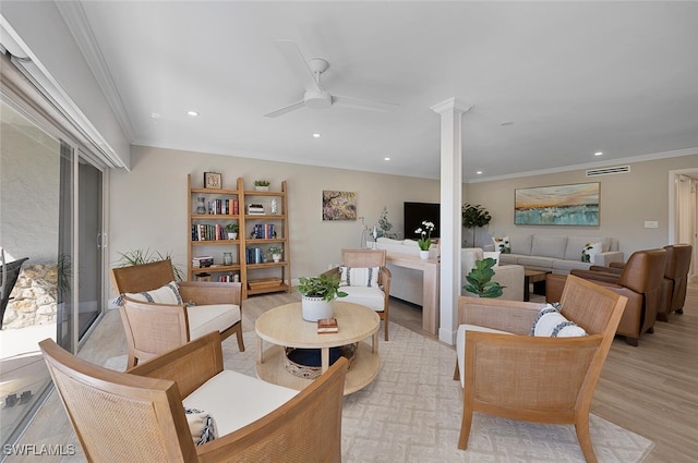 interior space with light wood finished floors, ornamental molding, ornate columns, recessed lighting, and a ceiling fan