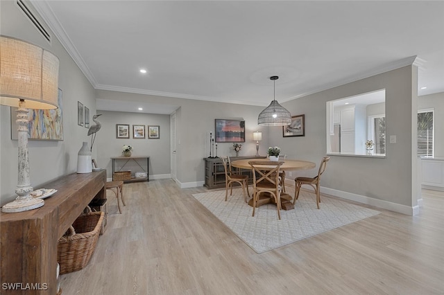 dining space featuring light wood-style floors, visible vents, and baseboards