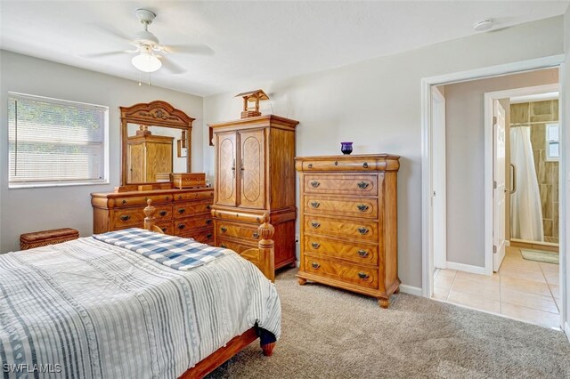 bedroom with light tile patterned floors, ceiling fan, baseboards, and light colored carpet