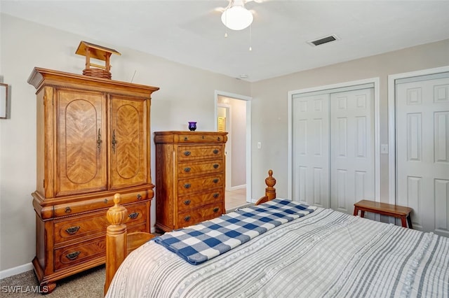 bedroom with light carpet, ceiling fan, visible vents, and baseboards