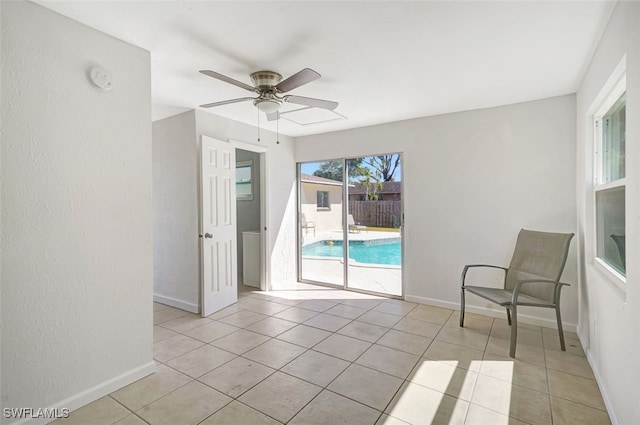 unfurnished room with ceiling fan, baseboards, and light tile patterned flooring