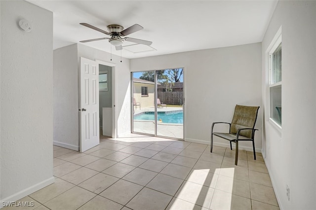 unfurnished room with a ceiling fan, baseboards, and light tile patterned floors